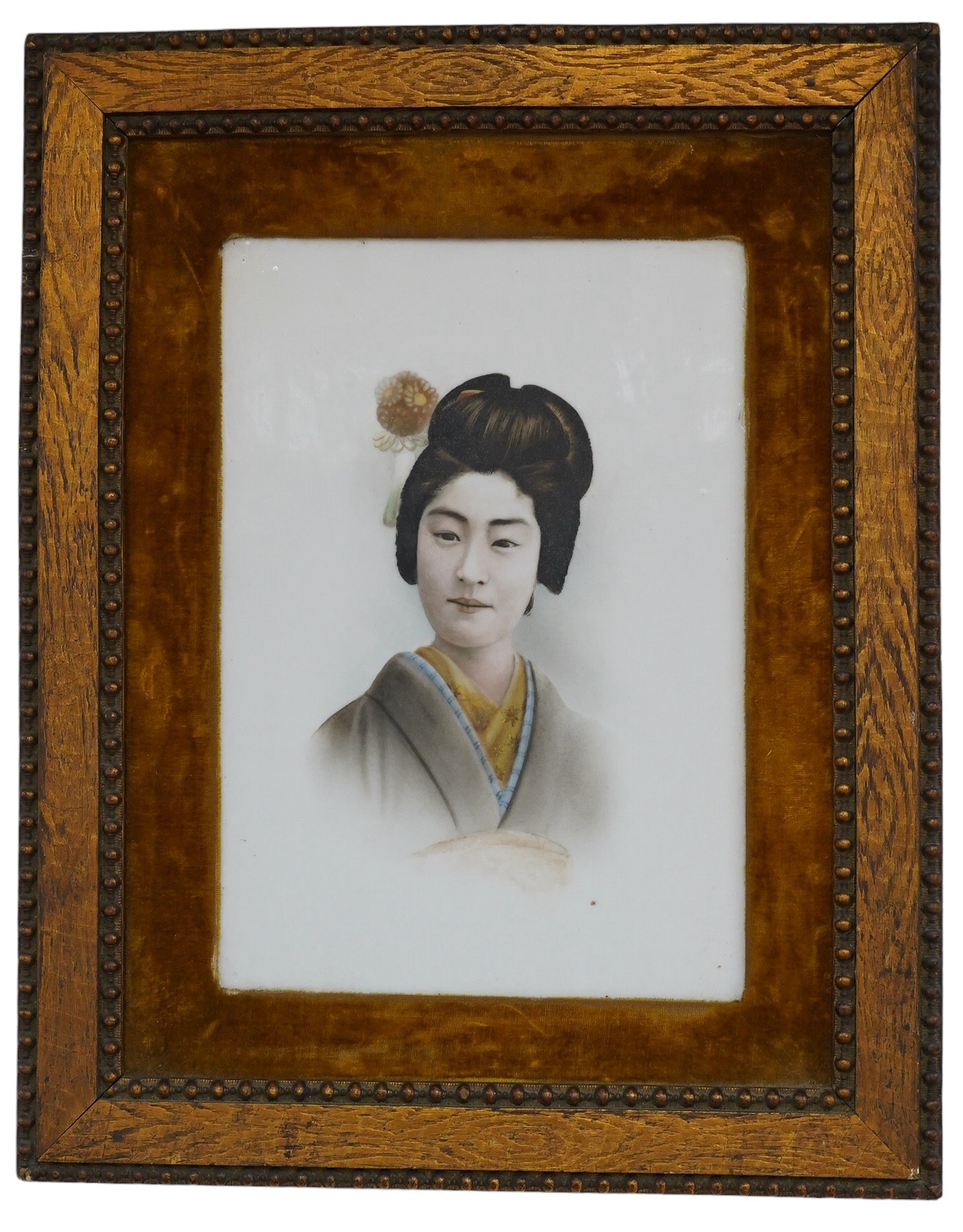 A framed Japanese painted porcelain plaque of a Geisha, 24cm wide, 33cm high. Condition - fair